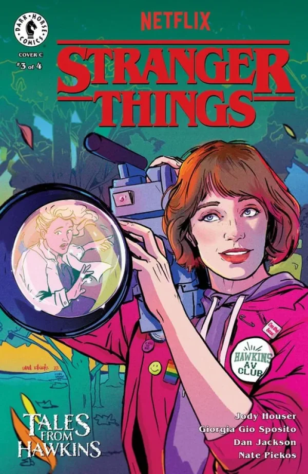 Liana Kangas cover for Stranger Things: Tales from Hawkins #3, a young woman holding a camcorder with another figure reflected in the lens.